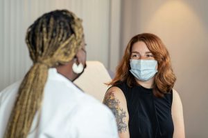 A woman in a mask getting a doctor's examination for early detection of fibroids