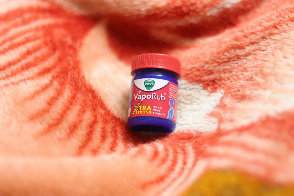 A jar of Vicks VapoRub on a red and white background