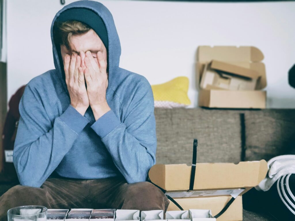 man covering his face with his hands
